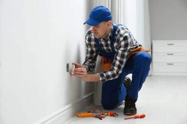 Electrician working on a wall outlet