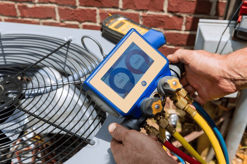 Technician checking refrigerant levels during AC tune-up in Shreveport Louisiana